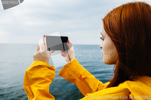 Image of Girl taking photo of ocean