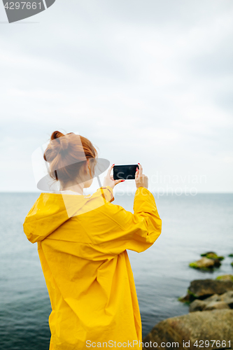Image of Girl taking photo of ocean