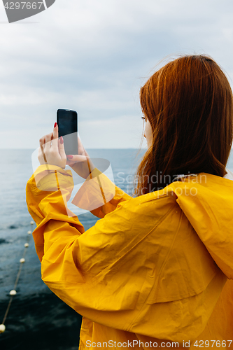 Image of Girl taking photo of ocean