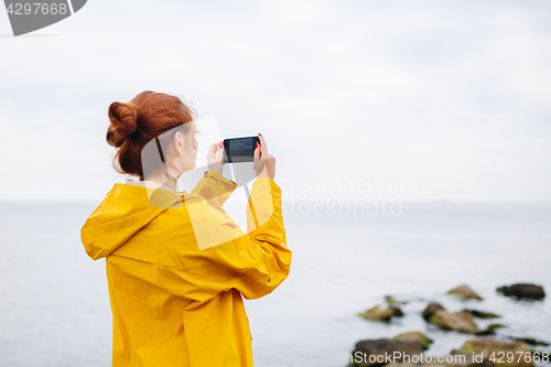 Image of Girl taking photo of ocean