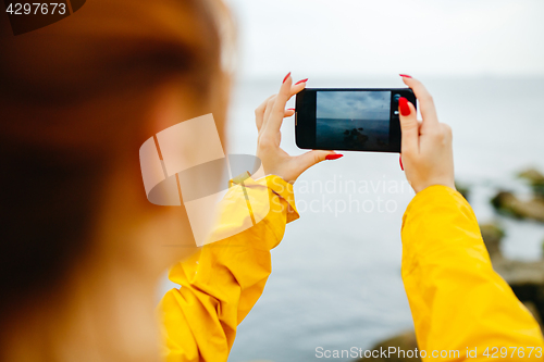 Image of Girl taking photo of ocean