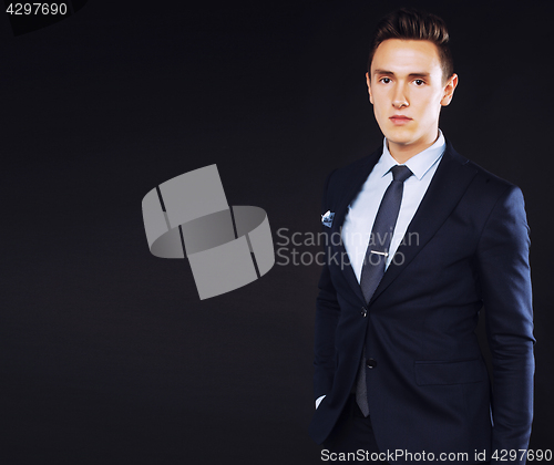 Image of young pretty business man standing on black background, modern h