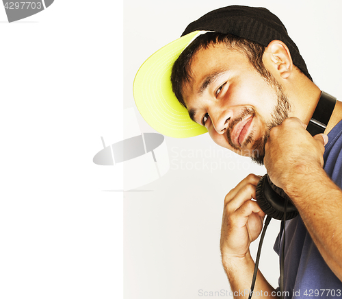 Image of young asian man in hat and headphones listening music on white b