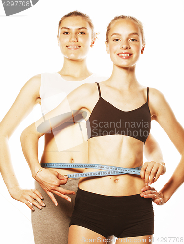 Image of two sport girls measuring themselves isolated on white