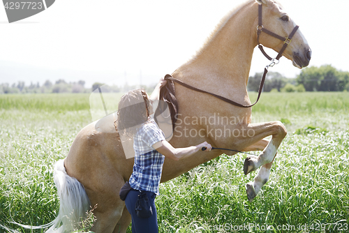 Image of Woman training horse to rear up