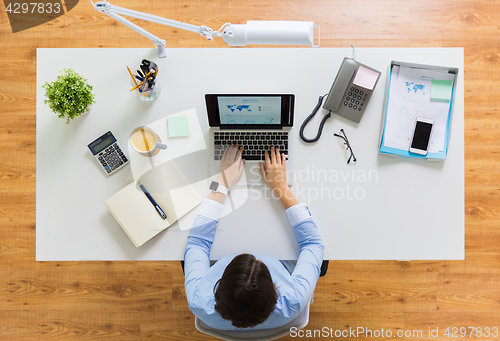 Image of businesswoman working on laptop at office