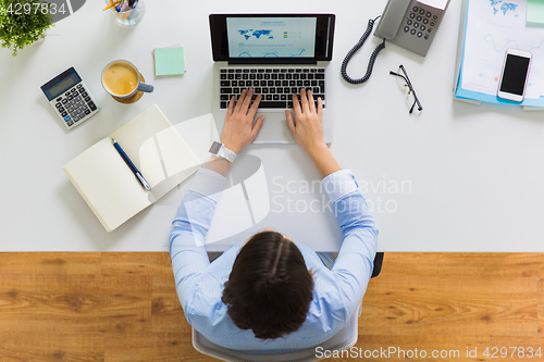 Image of businesswoman working on laptop at office