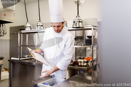 Image of chef with clipboard doing inventory at kitchen