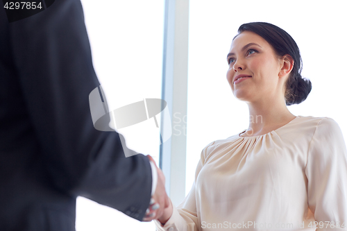 Image of smiling business people shaking hands at office
