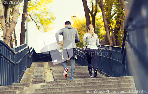 Image of couple running upstairs in city park