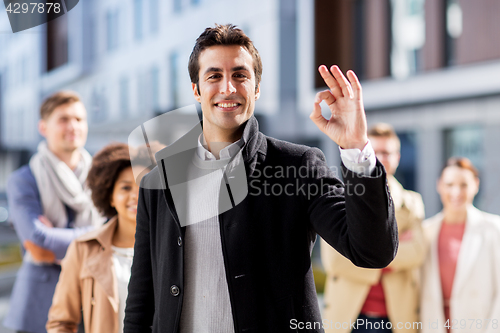 Image of international business team showing ok hand sign