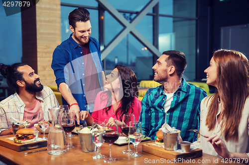 Image of friends dining and drinking wine at restaurant