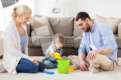 Image of happy family playing with beach toys at home