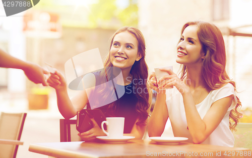 Image of women with credit card paying for coffee at cafe