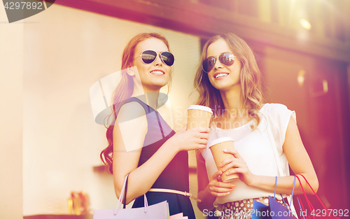 Image of young women with shopping bags and coffee at shop