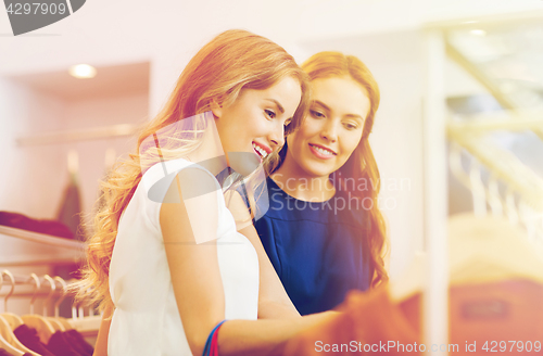 Image of happy women choosing clothes at clothing shop