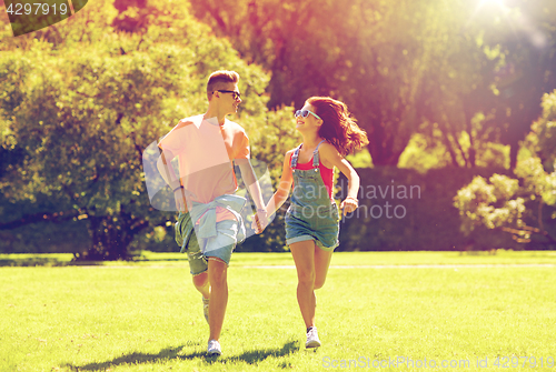 Image of happy teenage couple running at summer park