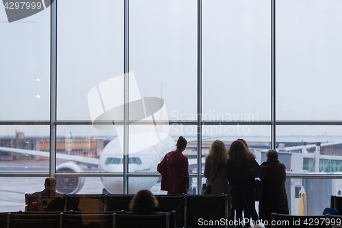 Image of People waiting for airplane departure on a rainy day.