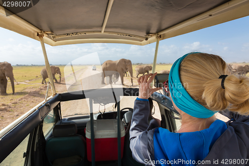 Image of Woman taking photos on african wildlife safari. Amboseli, Kenya.