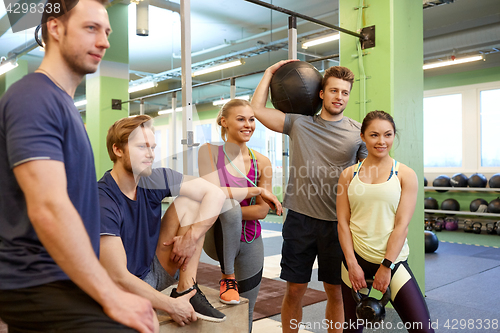 Image of group of friends with sports equipment in gym