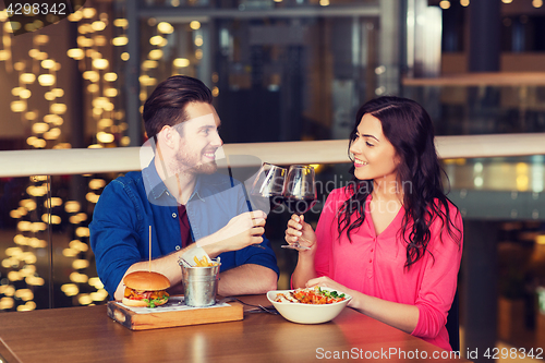 Image of happy couple dining and drink wine at restaurant