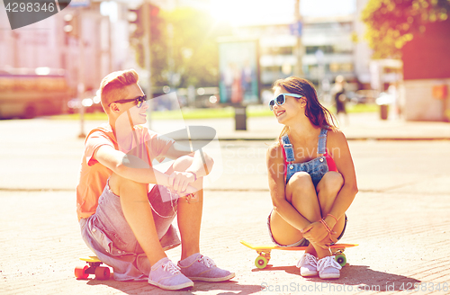 Image of teenage couple with skateboards on city street