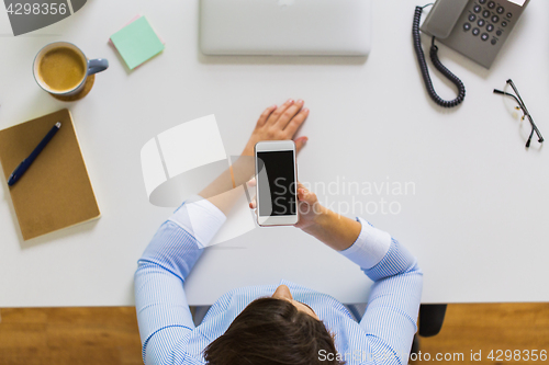 Image of businesswoman with smartphone working at office