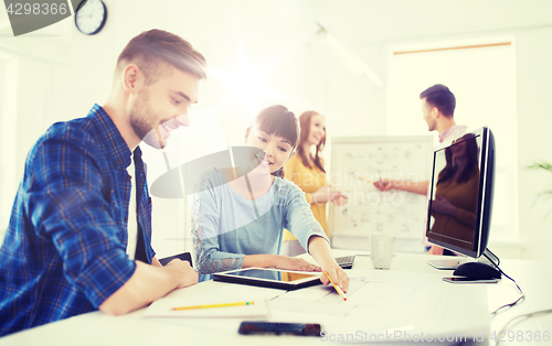 Image of creative team with blueprint at office
