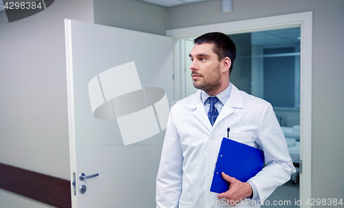 Image of doctor with clipboard at hospital corridor