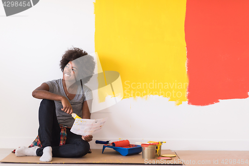 Image of back female painter sitting on floor