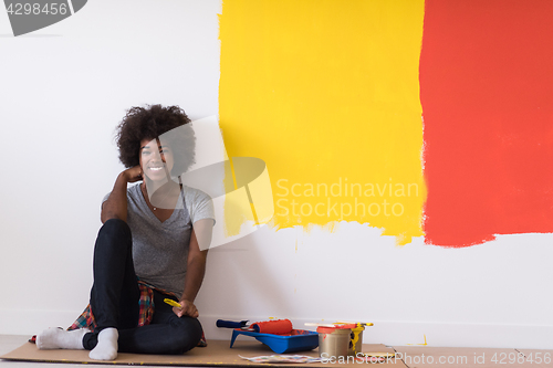 Image of back female painter sitting on floor