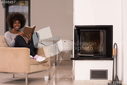 Image of black woman at home reading book