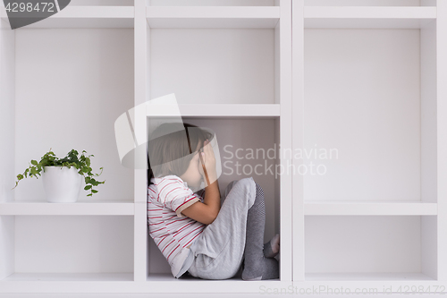 Image of young boy posing on a shelf