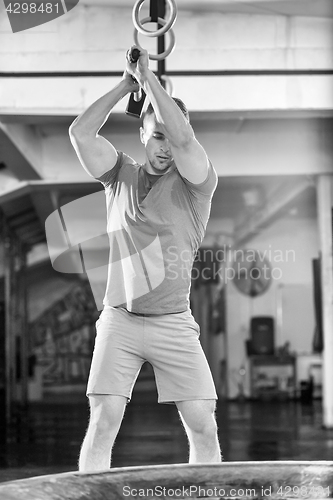 Image of man workout with hammer and tractor tire
