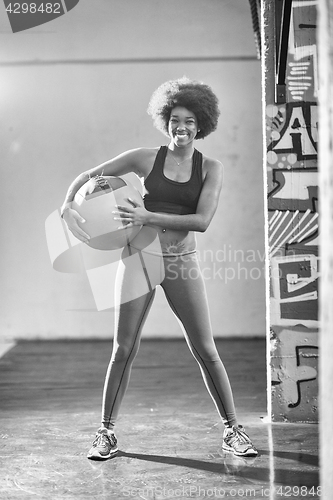 Image of black woman carrying crossfit ball