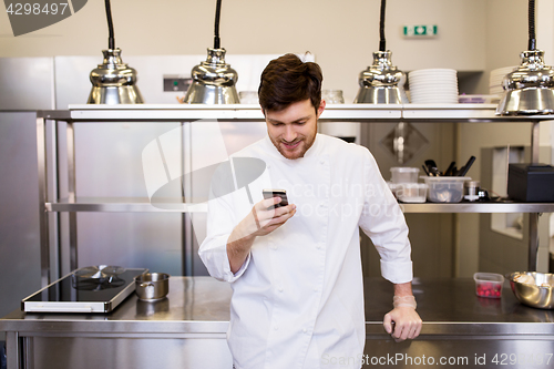 Image of chef cook with smartphone at restaurant kitchen