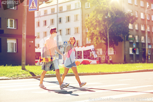 Image of teenage couple with skateboards on city street