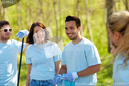 Image of volunteers with garbage bags cleaning park area