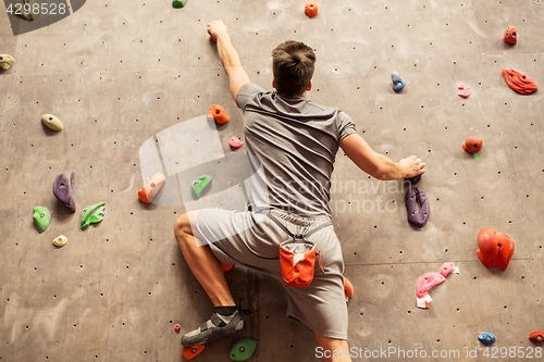 Image of young man exercising at indoor climbing gym