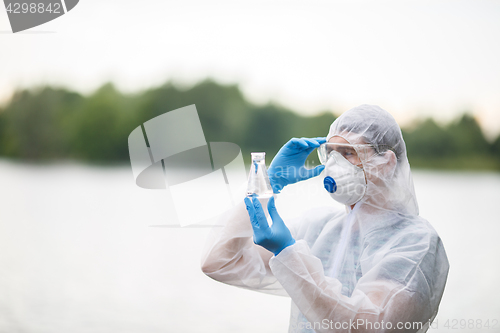 Image of Chemist holds flask with water