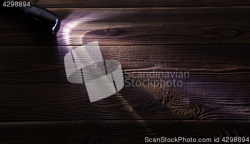 Image of Wooden background with glowing flashlight