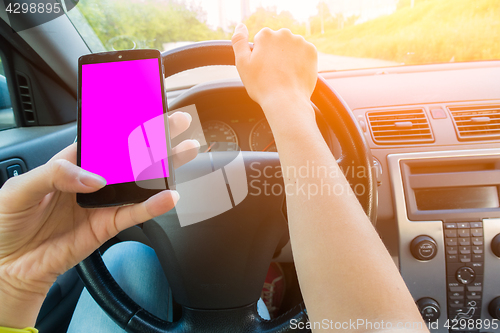 Image of Girl holding smartphone in car