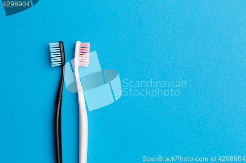 Image of Black , pink toothbrushes, space for text