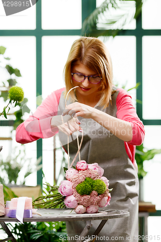 Image of Florist makes bouquet of flowers