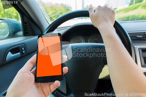 Image of Driver holding smartphone in car