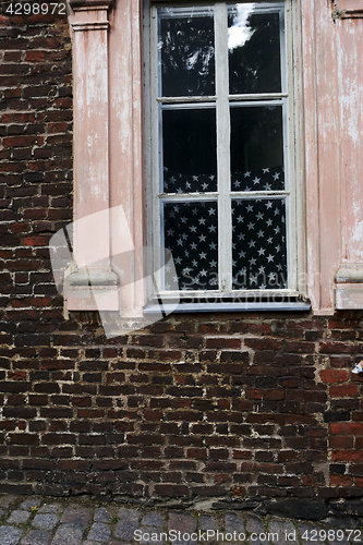 Image of brick wall and american flag in the window