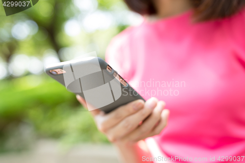 Image of Woman use of phone at outdoor park