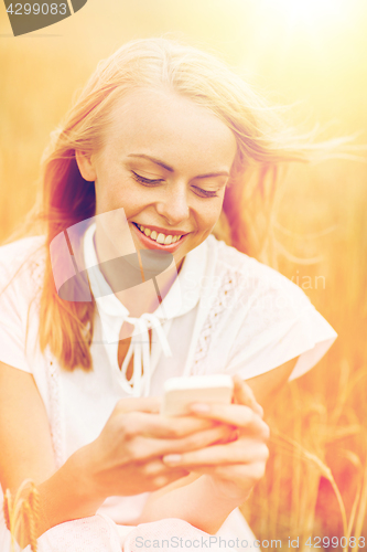 Image of happy young woman with smartphone on cereal field