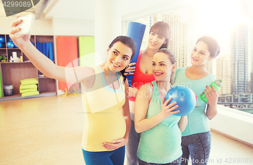 Image of pregnant women taking selfie by smartphone in gym