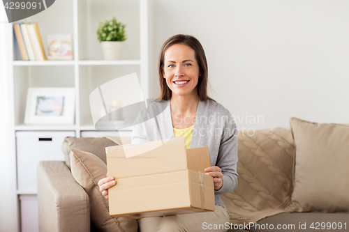 Image of smiling woman opening cardboard box